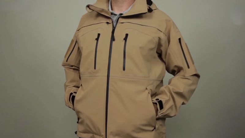 A Person Wearing a Tan Tactical Jacket with Multiple Pockets and A Hood