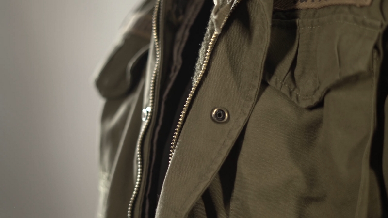 A Close-Up of A Green Tactical Jacket with A Zipper and Buttons