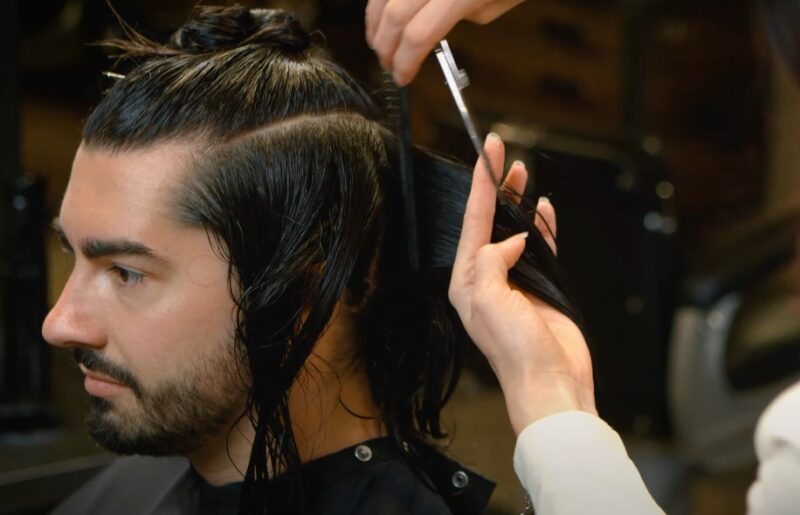 A skilled stylist expertly trims wet hair, showcasing precision and control