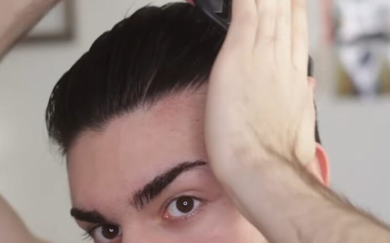 A close-up view of hands styling wet hair, creating a defined look