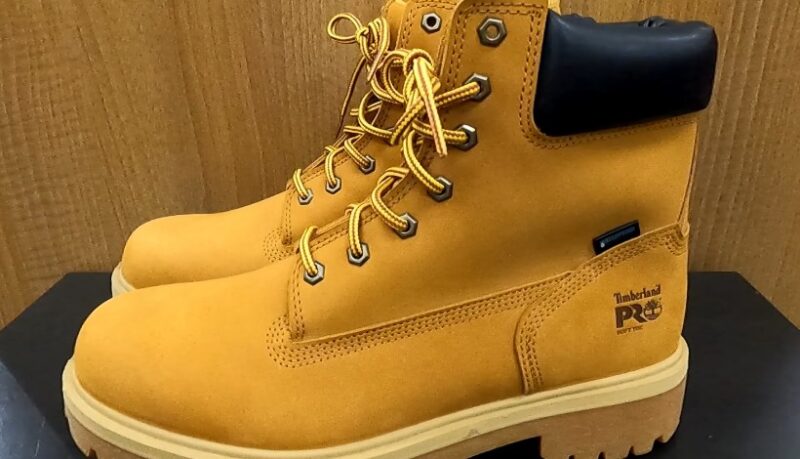 A pair of yellow timber boots resting on a wooden table